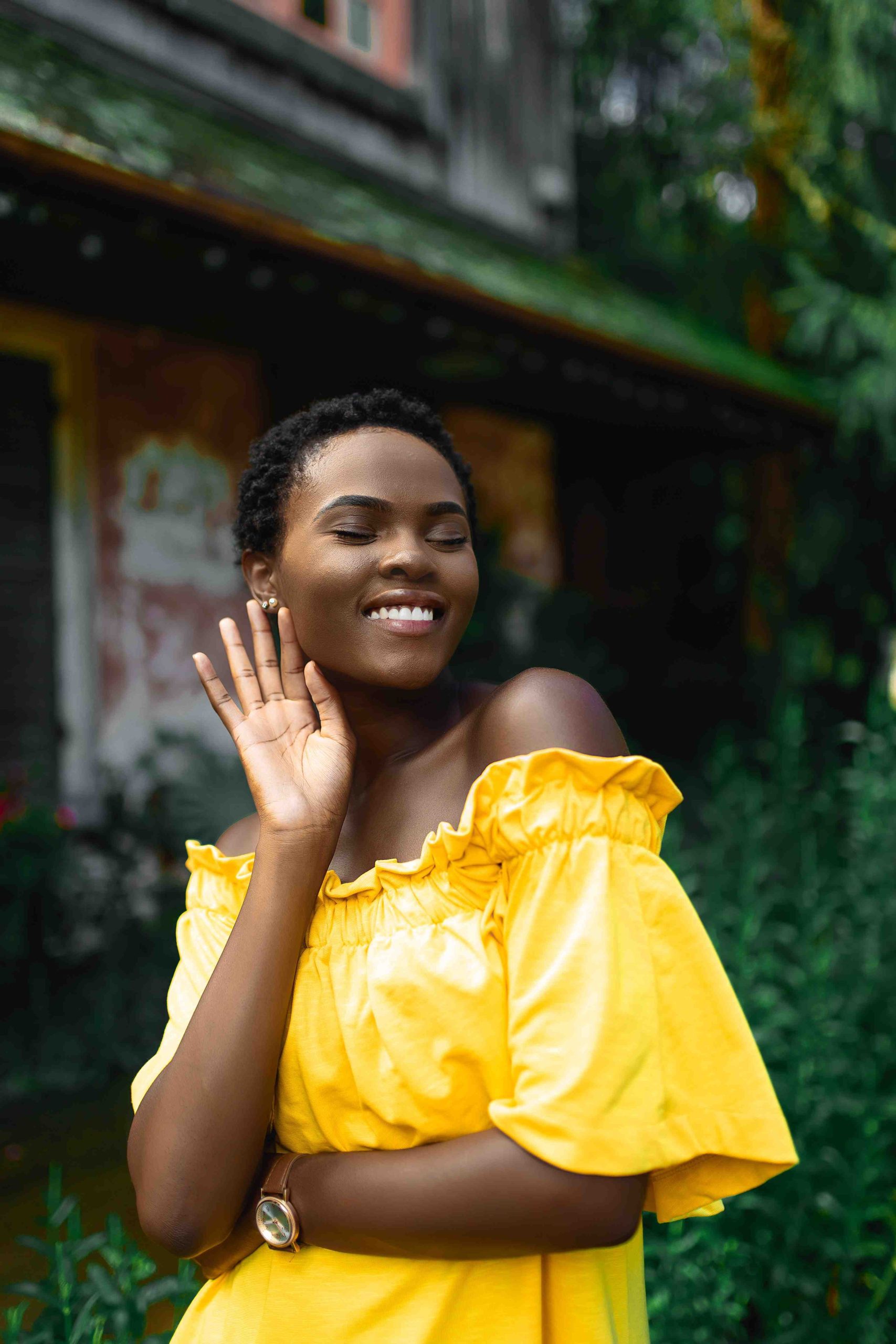 Black Woman with Short Hair Smiling and Touch Her Face